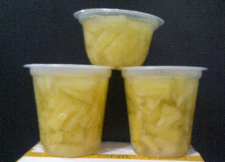 Pineapple cubes in sugar syrup in glass jar
